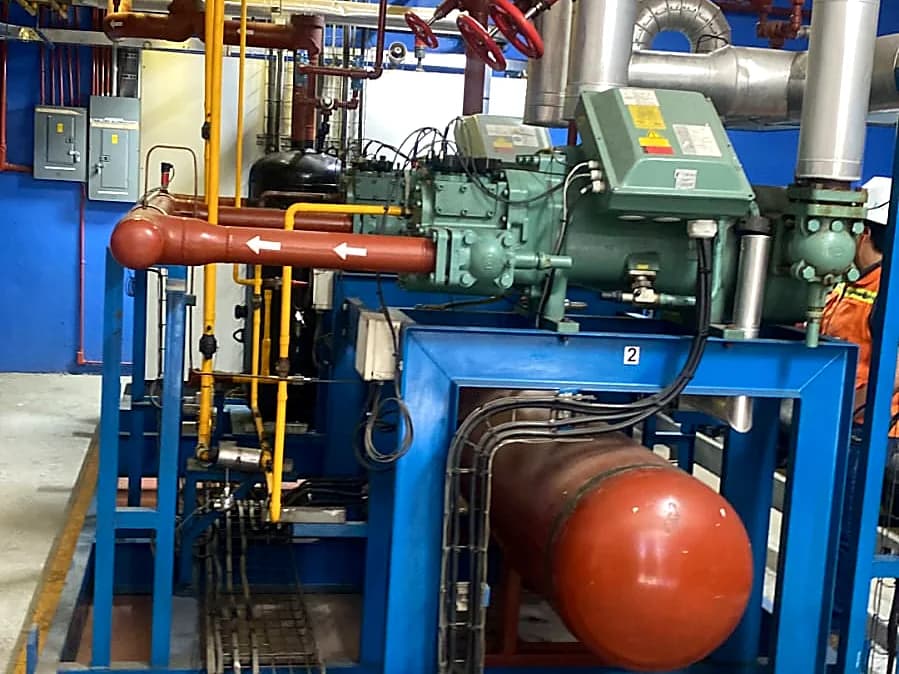 Sala de máquinas con compresor de refrigeración, recibidor de amoniaco y tubería de proceso sobre patín